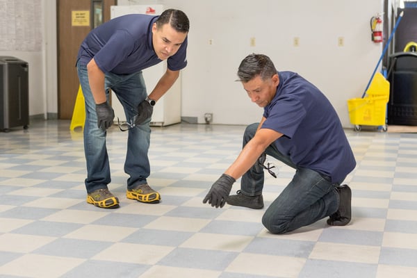 Two men inspecting a floor before finishing